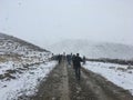 Group of people walking on dirt road in snow