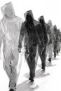 A group of people walking in a line with their hoods up, AI