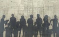 Group of people walking in a relaxed pose cast a shadow on the concrete wall. Conceptual creative illustration with silhouettes of