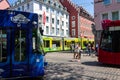 Group of people walking on a street with trams passing in downtown Freiburg, Germany, Europe