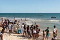 Group of people watching fishermen in canoes near the sea at Boca do Rio beach