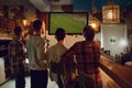 A group of people watching tv football in a sports bar. Royalty Free Stock Photo