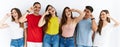 Group of people wearing casual clothes standing over isolated background doing peace symbol with fingers over face, smiling Royalty Free Stock Photo