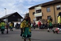 Group of people wearing colorful costumes are marching on a traditional fool's carnival parade