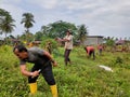 a group of people who are cleaning the grave yard in the Peulalu village area