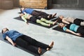 Group of people at yoga class, lying on floor after exerices