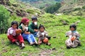 Group of Peruvian children sharing Christmas breakfast sitting in the grass eating bread.