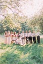 The group photo of the groom and his best men, the bride with the bridemaids behing the white bicycle at the background