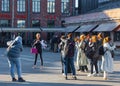 A group of photographers takes pictures of a model at an outdoor photography workshop.