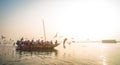 Pilgrims approaching the East bank of the sacred Ganges river by boat at sunrise in Varanasi, Uttar Pradesh, India. Royalty Free Stock Photo
