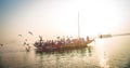 Pilgrims approaching the East bank of the sacred Ganges river by boat at sunrise in Varanasi, Uttar Pradesh, India. Royalty Free Stock Photo