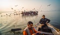 Pilgrims approaching the East bank of the sacred Ganges river by boat at sunrise in Varanasi, Uttar Pradesh, India. Royalty Free Stock Photo