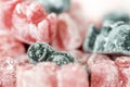 A group of pink and black jelly sweets with a dark sweet figure with a heart emblem on its front standing