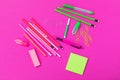 Group of pink and bright green stationery on pink background isolated