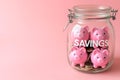 Group of pink piggy banks in a glass jar on pink. Personal savings and financial investment, money storage, money boxes. Finance Royalty Free Stock Photo