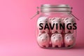 Group of pink piggy banks in a glass jar on pink. Personal savings and financial investment, money storage, money boxes. Finance Royalty Free Stock Photo