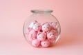 Group of pink piggy banks in a glass jar on pink. Personal savings and financial investment, money storage, money boxes. Finance