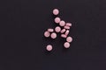 Group pink tablets. Black background.