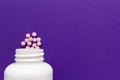 Group pink tablets. Capsules spilling out of white bottle. Royalty Free Stock Photo