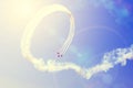 A group of planes perform a dead loop leaving a smoky trail in the rays of the bright sun Royalty Free Stock Photo