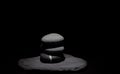 Group of poised stones under a soft light on a black background Royalty Free Stock Photo
