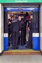 A group of policemen gets into an underground subway car