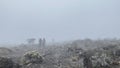 A group of porters with large backpacks and trunks on their heads. Foggy mountain landscape. Climbing Kilimanjaro, Africa Royalty Free Stock Photo