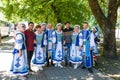 Group portrait of an amateur Belarusian collective in ethnic costumes and two Pakistani guys at the traditional All