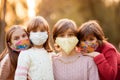 Group portrait of children in protective medical masks walking on street on sunset Royalty Free Stock Photo