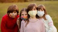 Group portrait of children in protective medical masks walking on street on sunset Royalty Free Stock Photo