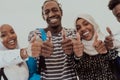 Group portrait of happy African students standing together against a white background and showing ok sign thumbs up Royalty Free Stock Photo