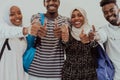 Group portrait of happy African students standing together against a white background and showing ok sign thumbs up Royalty Free Stock Photo