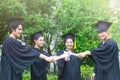 Group of Portrait happy students in graduation gowns holding diplomas on university campus Royalty Free Stock Photo