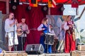 Group portrait of a male and female musician in traditional medieval clothes playing and singing songs during an annual medieval