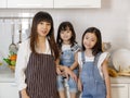 Group portrait of mother and two little daughters taking photo together in modern kitchen Royalty Free Stock Photo