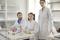 Group portrait of serious young scientists in lab coats and goggles in their laboratory