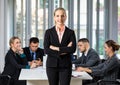 Group portrait of six business people team sitting and talking in conference together in an office and while the woman boss stand Royalty Free Stock Photo