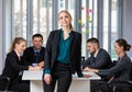 Group portrait of six business people team sitting and talking in conference together in an office and while the woman boss stand Royalty Free Stock Photo