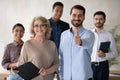 Group portrait of smiling multiracial employees with older senior leader.