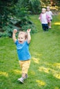 Group portrait of three white Caucasian blond adorable cute kids playing running in park garden outside Royalty Free Stock Photo