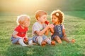 Children boy and girls sitting together sharing and eating apple food Royalty Free Stock Photo