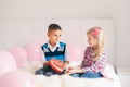 Boy giving girl chocolate gift present to celebrate Valentine Day