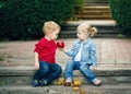 Group portrait of two white Caucasian cute adorable funny children toddlers sitting together sharing apple food Royalty Free Stock Photo