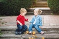 Two white Caucasian cute adorable funny children toddlers sitting together sharing eating apple food