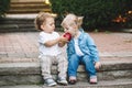 Two white Caucasian cute adorable funny children toddlers sitting together sharing eating apple food