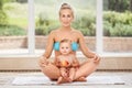 Group portrait of white Caucasian mother and baby daughter doing physical fitness exercises yoga together sitting in lotus pose on Royalty Free Stock Photo