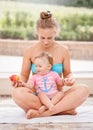 Group portrait of white Caucasian mother and baby daughter doing physical fitness exercises yoga together sitting in lotus pose on Royalty Free Stock Photo