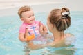 Group portrait of white Caucasian mother and baby daughter playing in water in swimming pool Royalty Free Stock Photo