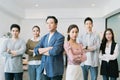 Group Portrait of young asian businesspeople standing indoors in office, looking at camera.Successful and confident business team Royalty Free Stock Photo