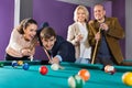 Group of positive friends playing billiards Royalty Free Stock Photo